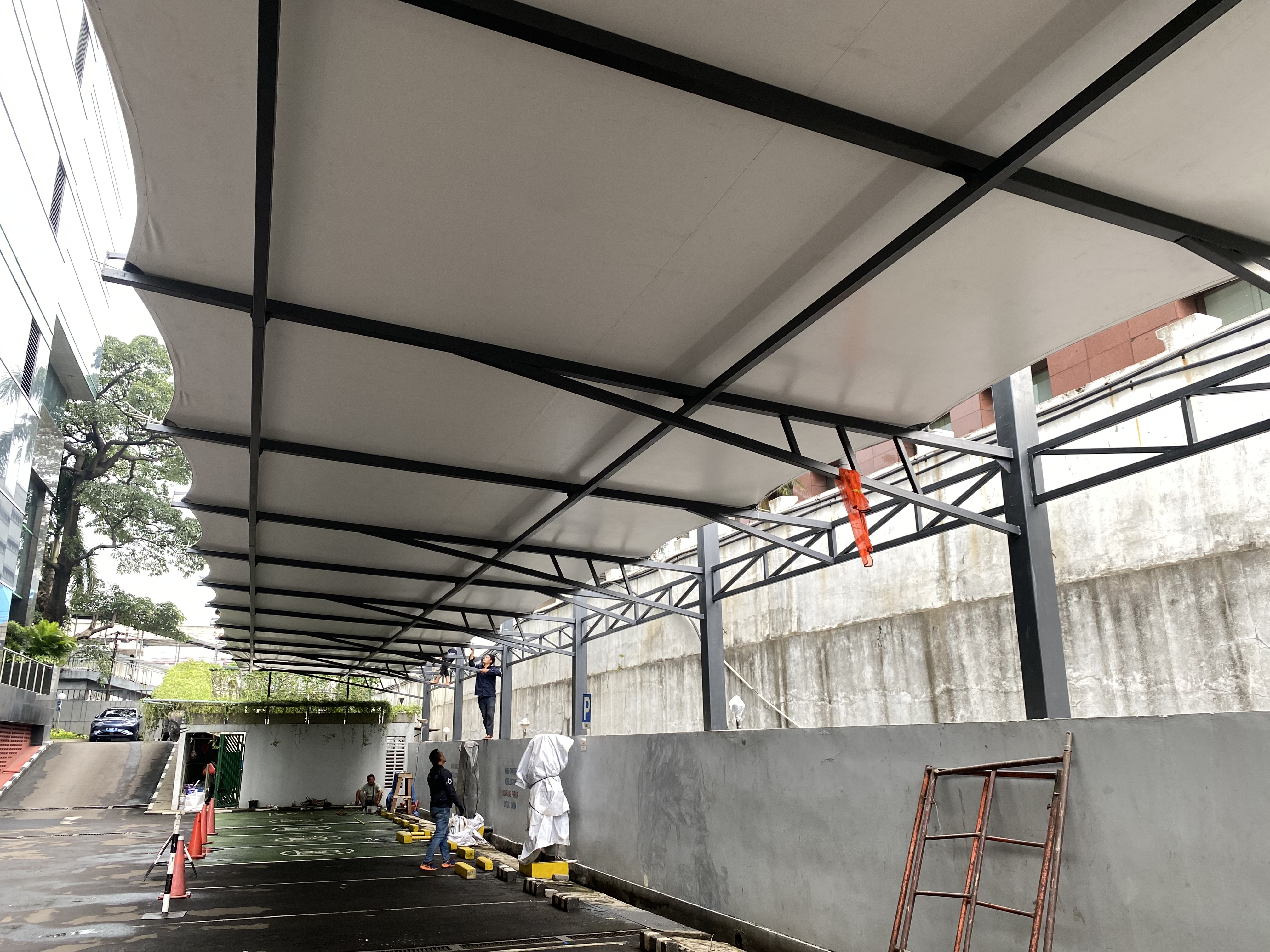 Instalasi kanopi membran di WISMA MILLENIA untuk parkir